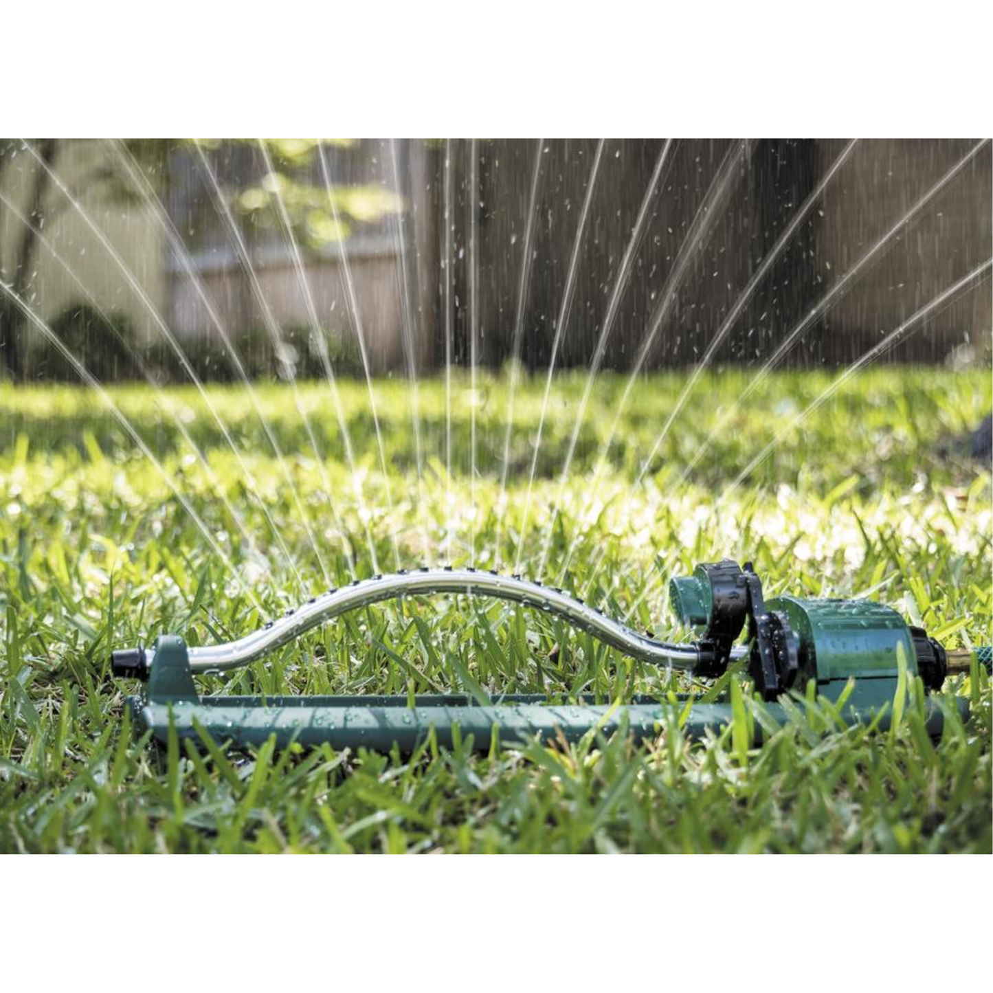 Sprinkler watering a grassy area with water spraying out