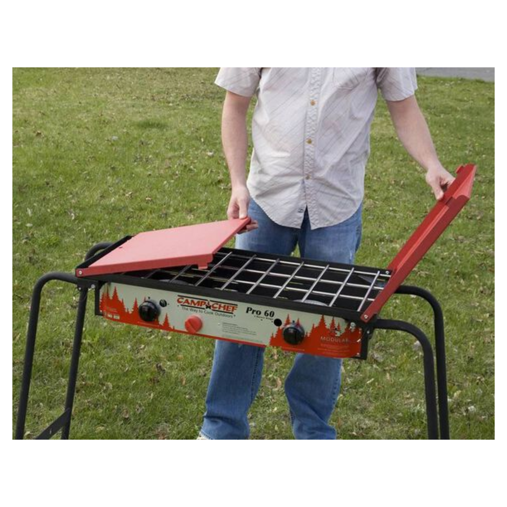 Man folding the cover on a black and red grill.