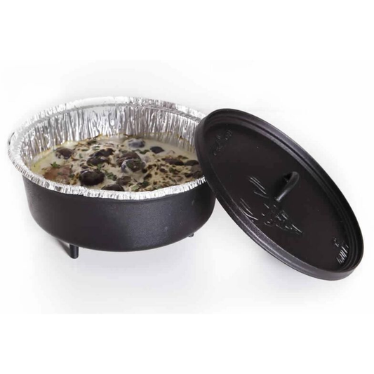 A dutch oven with a disposable liner and food in it.